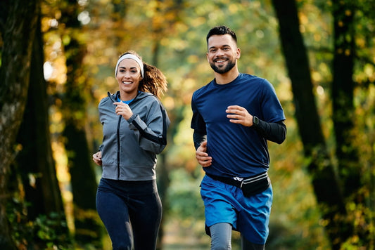Happy athletic couple jogging during fall season