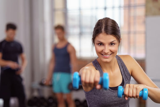woman enthusiastic expression using blue dumbbell weights